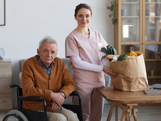 A caregiver providing daily living assistance to a client in their home