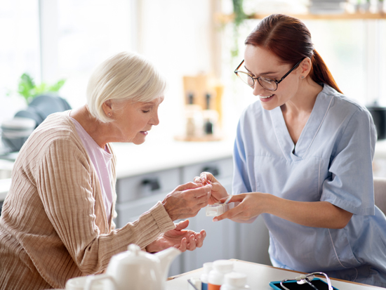 A caregiver providing senior care to a client in their home